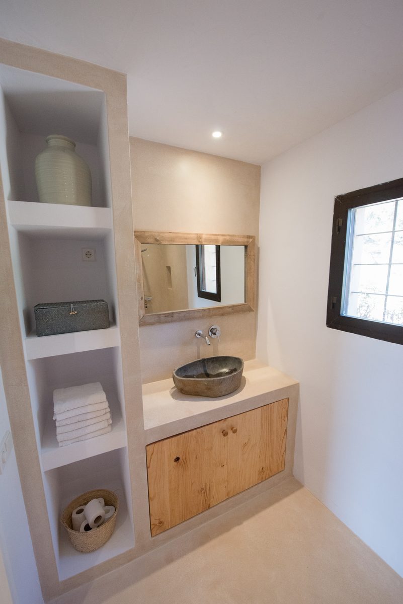 Second bathroom with stone basin and wooden shelving at Can Beteigeuze