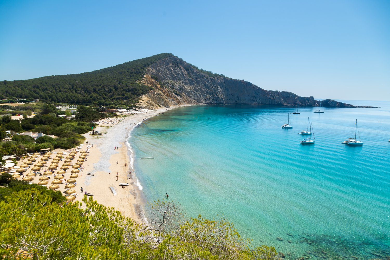 Aerial view of Cala Vadella with turquoise water and sailboats