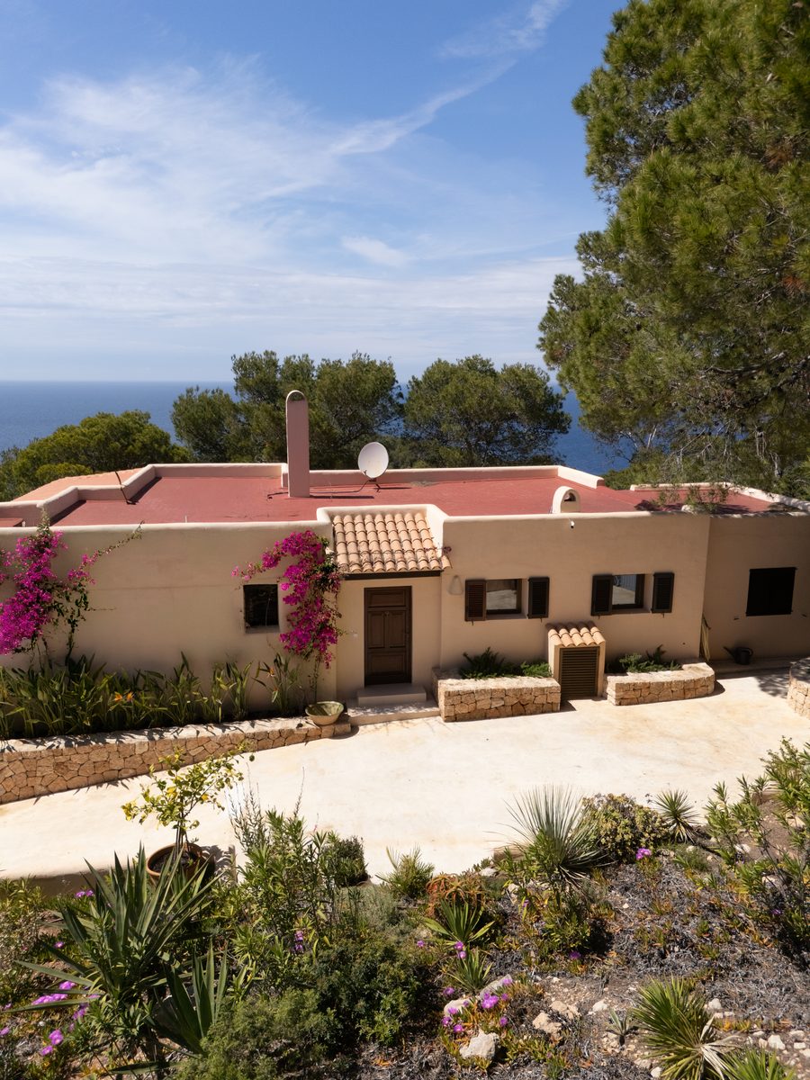 Can Beteigeuze villa exterior with bougainvillea and sea in background