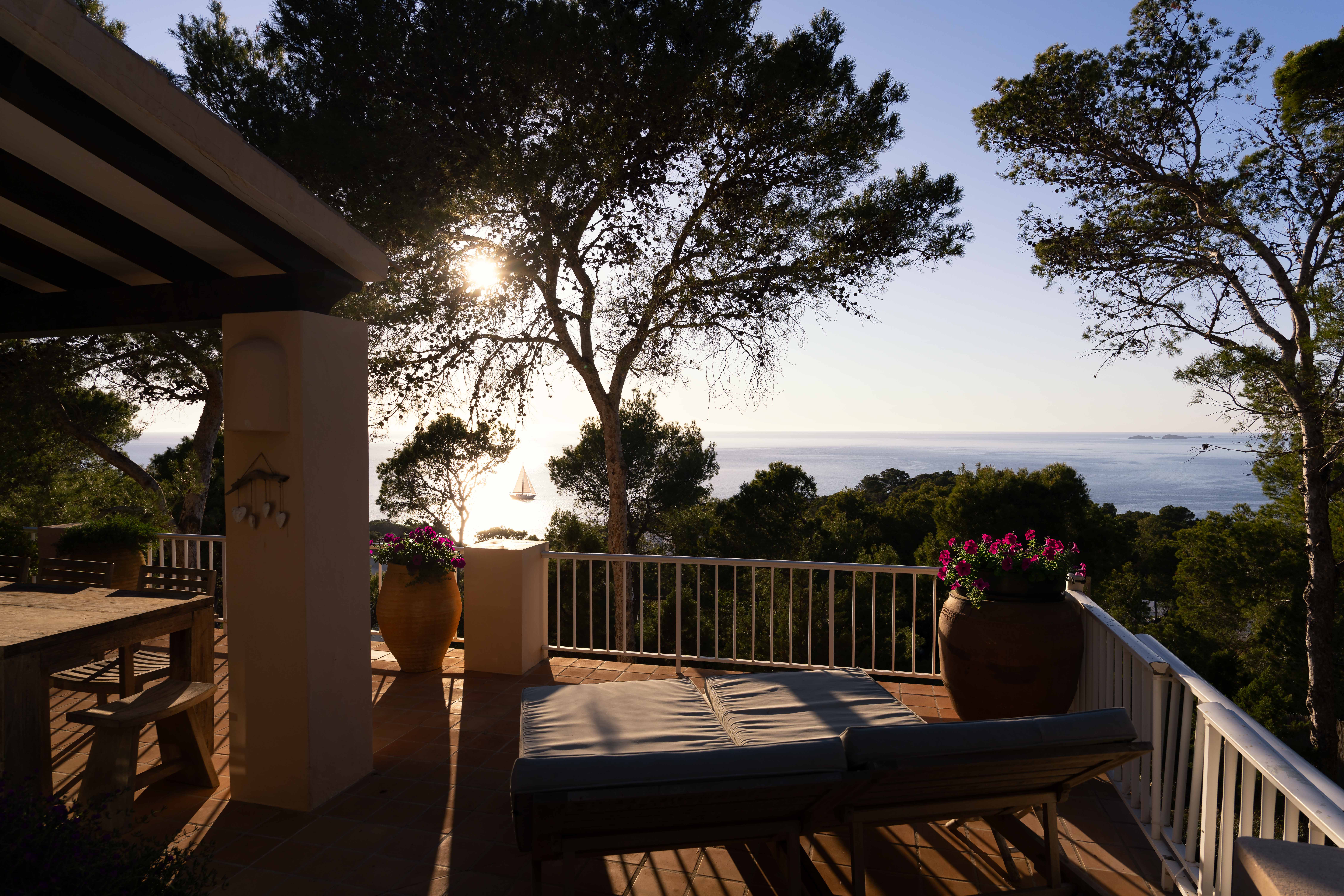 Covered terrace with outdoor dining table and sea view at Can Beteigeuze